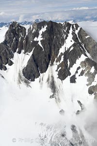 The Kenai Mountains rise above thick ice sheets and the Harding Icefield which is one of the largest icefields in Alaska and gives rise to over 30 glaciers, Kenai Fjords National Park