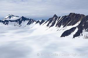 The Kenai Mountains rise above thick ice sheets and the Harding Icefield which is one of the largest icefields in Alaska and gives rise to over 30 glaciers, Kenai Fjords National Park