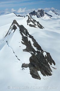 The Kenai Mountains rise above thick ice sheets and the Harding Icefield which is one of the largest icefields in Alaska and gives rise to over 30 glaciers, Kenai Fjords National Park