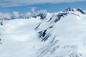 The Kenai Mountains rise above thick ice sheets and the Harding Icefield which is one of the largest icefields in Alaska and gives rise to over 30 glaciers, Kenai Fjords National Park