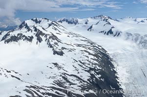 The Kenai Mountains rise above thick ice sheets and the Harding Icefield which is one of the largest icefields in Alaska and gives rise to over 30 glaciers, Kenai Fjords National Park