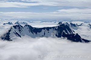 The Kenai Mountains rise above thick ice sheets and the Harding Icefield which is one of the largest icefields in Alaska and gives rise to over 30 glaciers, Kenai Fjords National Park