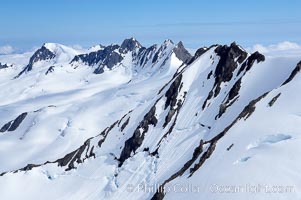 The Kenai Mountains rise above thick ice sheets and the Harding Icefield which is one of the largest icefields in Alaska and gives rise to over 30 glaciers, Kenai Fjords National Park