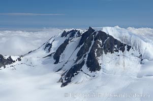 The Kenai Mountains rise above thick ice sheets and the Harding Icefield which is one of the largest icefields in Alaska and gives rise to over 30 glaciers, Kenai Fjords National Park