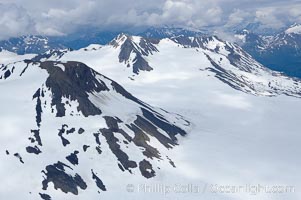 The Kenai Mountains rise above thick ice sheets and the Harding Icefield which is one of the largest icefields in Alaska and gives rise to over 30 glaciers, Kenai Fjords National Park
