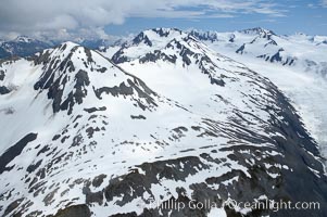 The Kenai Mountains rise above thick ice sheets and the Harding Icefield which is one of the largest icefields in Alaska and gives rise to over 30 glaciers, Kenai Fjords National Park