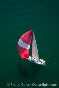 Sailboat under sail on the open ocean, spinnaker set and filled with wind