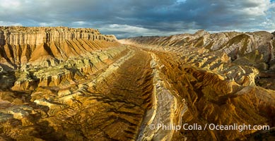 Aerial photo of the San Rafael Reef at dawn. This is a canyon-like section of the San Rafael Reef, photographed at sunrise. The "reef proper" is on the right, with its characteristic triangular flatiron erosion. The canyon in the center is a fold in the Earth's crust affiliated with the boundary of the San Rafael Swell.  The colors seen here arise primarily from Navajo and Wingate sandstone