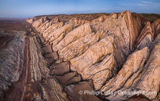 Aerial photo of the San Rafael Reef at dawn.  A fold in the Earth's crust leads to this inclined section of the San Rafael Reef, at the eastern edge of the San Rafael Swell.  Clearly seen are the characteristic triangular flatiron erosion patterns that typical this formation. The colors seen here arise primarily from Navajo and Wingate sandstone