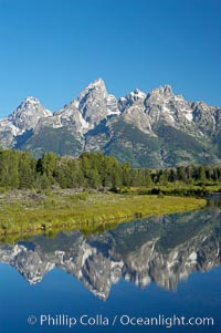 The Teton Range is reflected in the glassy waters of the Snake River at Schwabacher Landing, Grand Teton National Park, Wyoming