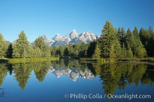 The Teton Range is reflected in the glassy waters of the Snake River at Schwabacher Landing, Grand Teton National Park, Wyoming