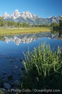 The Teton Range is reflected in the glassy waters of the Snake River at Schwabacher Landing.