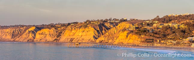 Scripps Pier and Blacks Beach, Sunset, Panorama. The Gold Coast of La Jolla basks in warm serene light as the sun sets over the Pacific Ocean