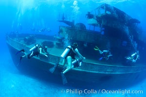 SCUBA divers on the wreck of the USS Kittiwake, sunk off Seven Mile Beach on Grand Cayman Island to form an underwater marine park and dive attraction