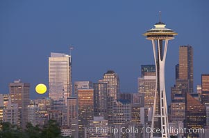 Full moon rises over Seattle city skyline at dusk, Space Needle at right