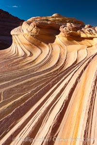 The Second Wave at sunset.  The Second Wave, a curiously-shaped sandstone swirl, takes on rich warm tones and dramatic shadowed textures at sunset.  Set in the North Coyote Buttes of Arizona and Utah, the Second Wave is characterized by striations revealing layers of sedimentary deposits, a visible historical record depicting eons of submarine geology, Paria Canyon-Vermilion Cliffs Wilderness