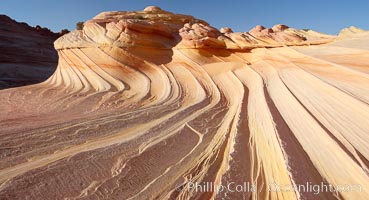 The Second Wave at sunset.  The Second Wave, a curiously-shaped sandstone swirl, takes on rich warm tones and dramatic shadowed textures at sunset.  Set in the North Coyote Buttes of Arizona and Utah, the Second Wave is characterized by striations revealing layers of sedimentary deposits, a visible historical record depicting eons of submarine geology, Paria Canyon-Vermilion Cliffs Wilderness