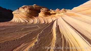 The Second Wave at sunset.  The Second Wave, a curiously-shaped sandstone swirl, takes on rich warm tones and dramatic shadowed textures at sunset.  Set in the North Coyote Buttes of Arizona and Utah, the Second Wave is characterized by striations revealing layers of sedimentary deposits, a visible historical record depicting eons of submarine geology, Paria Canyon-Vermilion Cliffs Wilderness