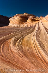 The Second Wave at sunset.  The Second Wave, a curiously-shaped sandstone swirl, takes on rich warm tones and dramatic shadowed textures at sunset.  Set in the North Coyote Buttes of Arizona and Utah, the Second Wave is characterized by striations revealing layers of sedimentary deposits, a visible historical record depicting eons of submarine geology, Paria Canyon-Vermilion Cliffs Wilderness