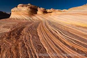 The Second Wave at sunset.  The Second Wave, a curiously-shaped sandstone swirl, takes on rich warm tones and dramatic shadowed textures at sunset.  Set in the North Coyote Buttes of Arizona and Utah, the Second Wave is characterized by striations revealing layers of sedimentary deposits, a visible historical record depicting eons of submarine geology, Paria Canyon-Vermilion Cliffs Wilderness