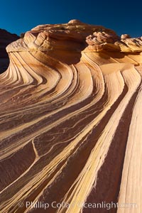 The Second Wave at sunset.  The Second Wave, a curiously-shaped sandstone swirl, takes on rich warm tones and dramatic shadowed textures at sunset.  Set in the North Coyote Buttes of Arizona and Utah, the Second Wave is characterized by striations revealing layers of sedimentary deposits, a visible historical record depicting eons of submarine geology, Paria Canyon-Vermilion Cliffs Wilderness