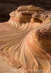 The Second Wave at Sunset, Vermillion Cliffs. The Second Wave, a curiously-shaped sandstone swirl, takes on rich warm tones and dramatic shadowed textures at sunset. Set in the North Coyote Buttes of Arizona and Utah, the Second Wave is characterized by striations revealing layers of sedimentary deposits, a visible historical record depicting eons of submarine geology