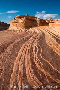 The Second Wave at Sunset, Vermillion Cliffs. The Second Wave, a curiously-shaped sandstone swirl, takes on rich warm tones and dramatic shadowed textures at sunset. Set in the North Coyote Buttes of Arizona and Utah, the Second Wave is characterized by striations revealing layers of sedimentary deposits, a visible historical record depicting eons of submarine geology, Paria Canyon-Vermilion Cliffs Wilderness