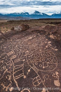 Sky Rock petroglyphs and storm clouds over the Eastern Sierran Nevada, near Bishop, California.  Hidden atop an enormous boulder in the Volcanic Tablelands lies Sky Rock, a set of petroglyphs that face the sky.  These superb examples of native American petroglyph artwork are thought to be Paiute in origin, but little is known about them