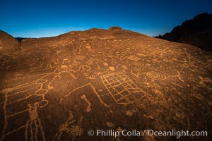 Sky Rock at night, light by moonlight with stars in the clear night sky above.  Sky Rock petroglyphs near Bishop, California. Hidden atop an enormous boulder in the Volcanic Tablelands lies Sky Rock, a set of petroglyphs that face the sky. These superb examples of native American petroglyph artwork are thought to be Paiute in origin, but little is known about them