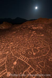 Sky Rock at night, light by moonlight with stars in the clear night sky above.  Sky Rock petroglyphs near Bishop, California. Hidden atop an enormous boulder in the Volcanic Tablelands lies Sky Rock, a set of petroglyphs that face the sky. These superb examples of native American petroglyph artwork are thought to be Paiute in origin, but little is known about them