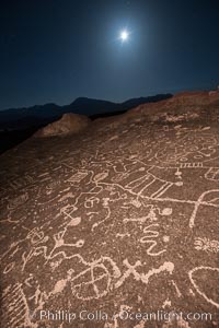 Sky Rock at night, light by moonlight with stars in the clear night sky above.  Sky Rock petroglyphs near Bishop, California. Hidden atop an enormous boulder in the Volcanic Tablelands lies Sky Rock, a set of petroglyphs that face the sky. These superb examples of native American petroglyph artwork are thought to be Paiute in origin, but little is known about them