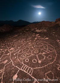 Sky Rock at night, light by moonlight with stars in the clear night sky above.  Sky Rock petroglyphs near Bishop, California. Hidden atop an enormous boulder in the Volcanic Tablelands lies Sky Rock, a set of petroglyphs that face the sky. These superb examples of native American petroglyph artwork are thought to be Paiute in origin, but little is known about them.