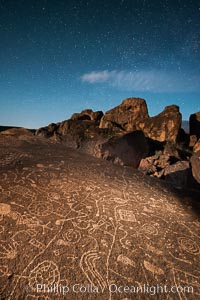 Sky Rock at night, light by moonlight with stars in the clear night sky above.  Sky Rock petroglyphs near Bishop, California. Hidden atop an enormous boulder in the Volcanic Tablelands lies Sky Rock, a set of petroglyphs that face the sky. These superb examples of native American petroglyph artwork are thought to be Paiute in origin, but little is known about them