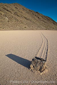 A sliding rock of the Racetrack Playa.  The sliding rocks, or sailing stones, move across the mud flats of the Racetrack Playa, leaving trails behind in the mud.  The explanation for their movement is not known with certainty, but many believe wind pushes the rocks over wet and perhaps icy mud in winter, Death Valley National Park, California