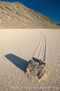 A sliding rock of the Racetrack Playa.  The sliding rocks, or sailing stones, move across the mud flats of the Racetrack Playa, leaving trails behind in the mud.  The explanation for their movement is not known with certainty, but many believe wind pushes the rocks over wet and perhaps icy mud in winter, Death Valley National Park, California