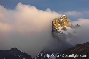 South Georgia Island, spire and sunset clouds, showing the island's characteristic rugged topography.  56% of the island is covered by 161 glaciers, which have created numerous large bays and inlets that provide excellent habitat for marine animals and seabirds. Mountains meet the sea in steep-sided seacliffs covered with sparse vegetation.  The highest point on South Georgia Island is Mt. Paget at 2,915m, Right Whale Bay