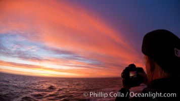 Photographer takes picture of a spectacular sunset arch, spanning the heavens from horizon to horizon, over the open sea between the Falkland Islands and South Georgia Island