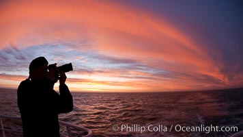 Photographer takes picture of a spectacular sunset arch, spanning the heavens from horizon to horizon, over the open sea between the Falkland Islands and South Georgia Island