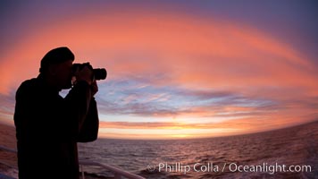 Photographer takes picture of a spectacular sunset arch, spanning the heavens from horizon to horizon, over the open sea between the Falkland Islands and South Georgia Island