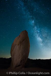 Standing stone and Milky Way, stars fill the night sky, Joshua Tree National Park, California