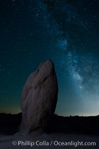 Standing stone and Milky Way, stars fill the night sky, Joshua Tree National Park, California