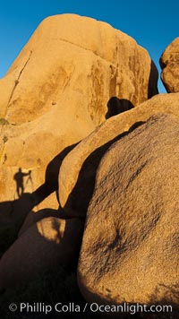 Sunrise on stone boulders, Joshua Tree National Park, desert southwest, photographer's shadow