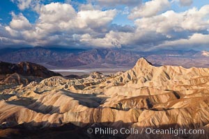 Sunrise at Zabriskie Point, Manly Beacon is lit by the morning sun while clouds from a clearing storm pass by, Death Valley National Park, California