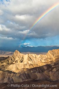 Sunrise at Zabriskie Point, Manly Beacon is lit by the morning sun while clouds from a clearing storm pass by, Death Valley National Park, California