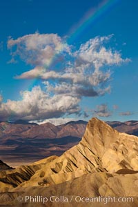 Sunrise at Zabriskie Point, Manly Beacon is lit by the morning sun while clouds from a clearing storm pass by, Death Valley National Park, California
