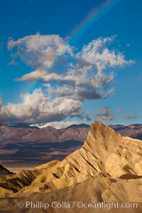 Sunrise at Zabriskie Point, Manly Beacon is lit by the morning sun while clouds from a clearing storm pass by, Death Valley National Park, California