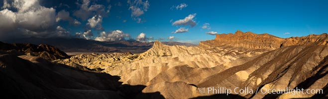 Sunrise at Zabriskie Point, Manly Beacon is lit by the morning sun while clouds from a clearing storm pass by, Death Valley National Park, California