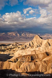 Sunrise at Zabriskie Point, Manly Beacon is lit by the morning sun while clouds from a clearing storm pass by, Death Valley National Park, California