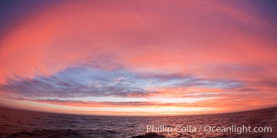 Sunset clouds create a colorful arch, spanning the heavens from horizon to horizon, over the open sea between the Falkland Islands and South Georgia Island
