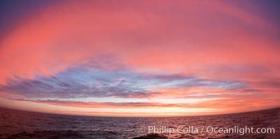 Sunset clouds create a colorful arch, spanning the heavens from horizon to horizon, over the open sea between the Falkland Islands and South Georgia Island